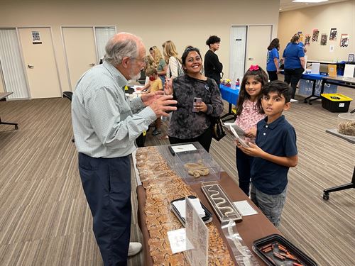 Volunteer describes the snake display at Family Science Night